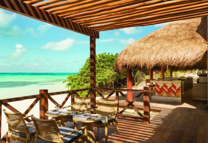 Turquoize at Hyatt Ziva Cancun adults-only all-inclusive gay-friendly hotel. Ocean view from a wooden deck with chairs and a thatched-roof bar.