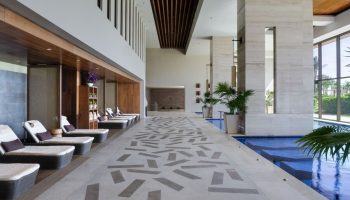 Turquoize at Hyatt Ziva Cancun adults-only all-inclusive gay-friendly hotel. Lounge chairs line an indoor pool, offering a relaxing spa experience.