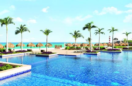 Turquoize at Hyatt Ziva Cancun adults-only all-inclusive resort pool. Gay-friendly hotel with beach, palm trees, and tiki umbrellas.