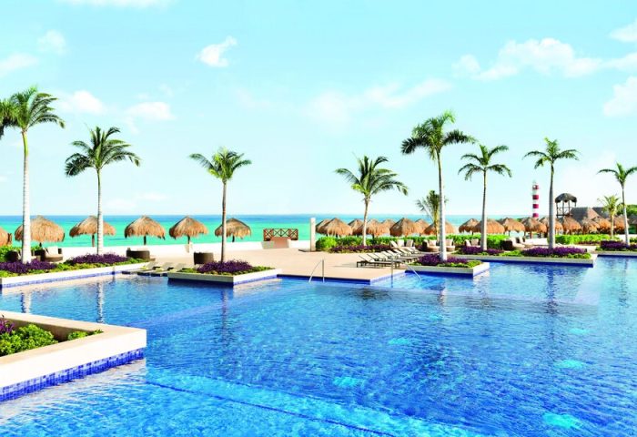 Turquoize at Hyatt Ziva Cancun adults-only all-inclusive resort pool. Gay-friendly hotel with beach, palm trees, and tiki umbrellas.