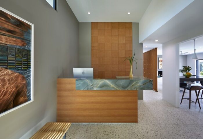 Twin Palms Resort's stylish reception area. Palm Springs gay men's resort with sleek design, wood accents, and modern art. Gay-friendly hotel.