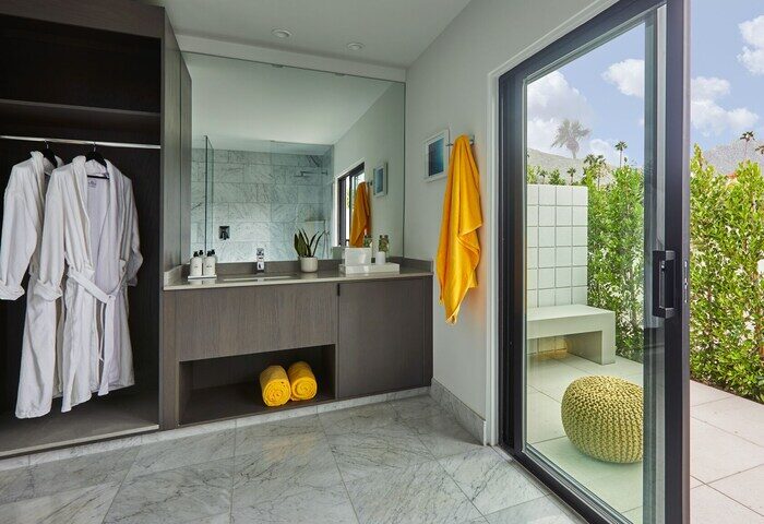 Bathroom at Twin Palms Resort, Palm Springs gay men's resort. Robes, vanity, and patio view. Gay-friendly hotel for discerning travelers.