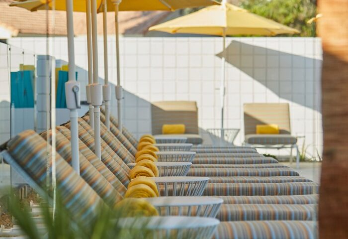 Twin Palms Resort, Palm Springs: Gay men's resort with yellow umbrellas and striped lounge chairs by the pool. Gay-friendly hotel for gay travel.