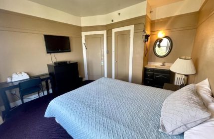 Twin Peaks Hotel room interior. Gay-friendly hotel with bed, desk, TV, and bathroom. Comfortable stay for gay men travelers.