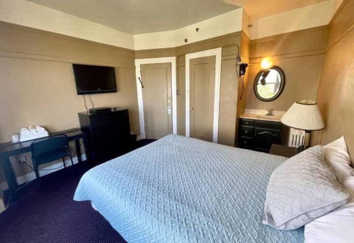 Twin Peaks Hotel room interior. Gay-friendly hotel with bed, desk, TV, and bathroom. Comfortable stay for gay men travelers.