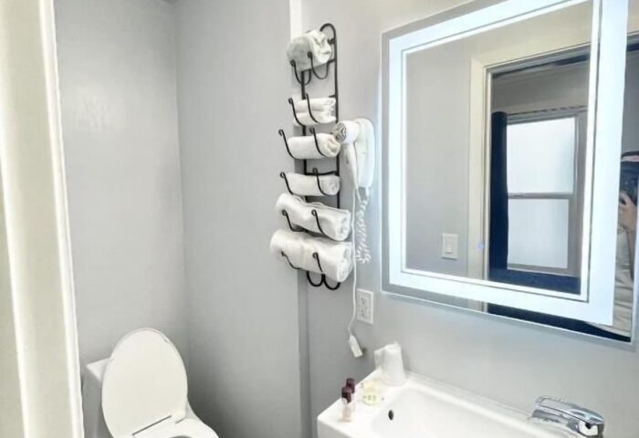 Bathroom at Twin Peaks Hotel, a gay-friendly hotel. Sink, toilet, and towels are visible. Gay travel advice for lodging.