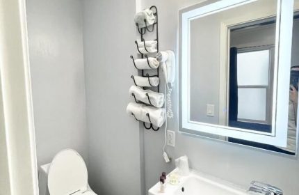Bathroom at Twin Peaks Hotel, a gay-friendly hotel. Sink, toilet, and towels are visible. Gay travel advice for lodging.