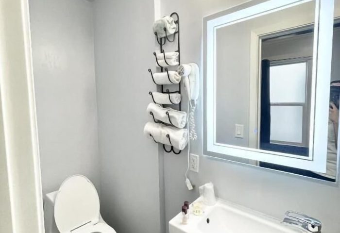 Bathroom at Twin Peaks Hotel, a gay-friendly hotel. Sink, toilet, and towels are visible. Gay travel advice for lodging.