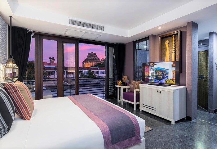 U Chiang Mai gay-friendly hotel room. Balcony view of Wat Chedi Luang. Modern design, purple accents. Ideal for gay travel in Chiang Mai.