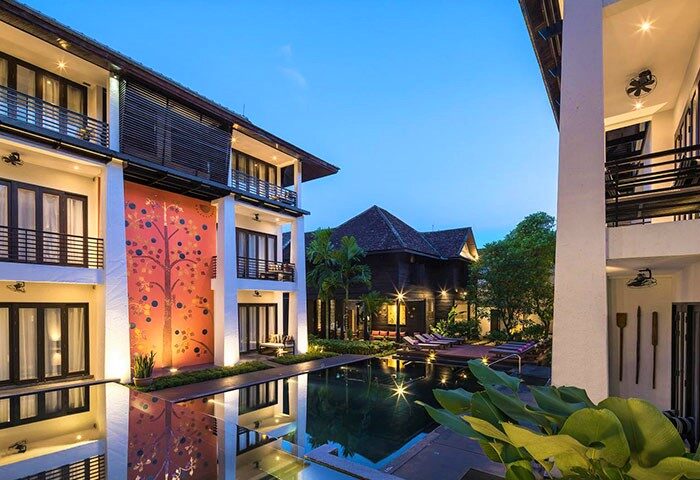 U Chiang Mai gay-friendly hotel view. Swimming pool reflects the hotel's unique tree art. A tranquil, welcoming space for gay travelers.