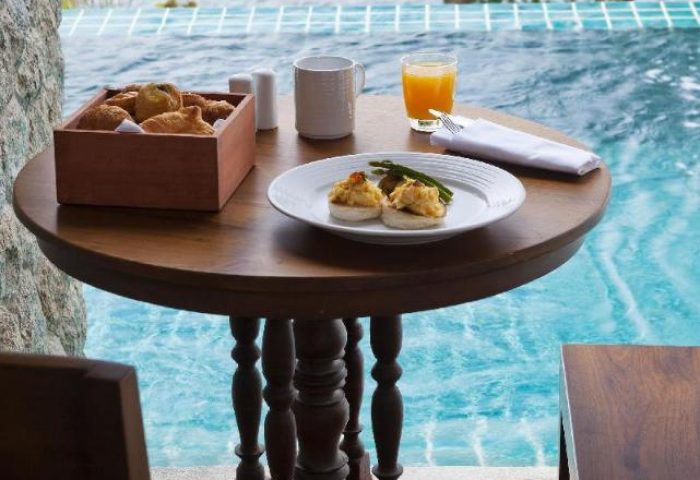 Breakfast by the pool at U Zenmaya Phuket Resort, a gay-friendly hotel. Enjoy pastries, juice, and eggs with a view. #GayPhuket #Thailand