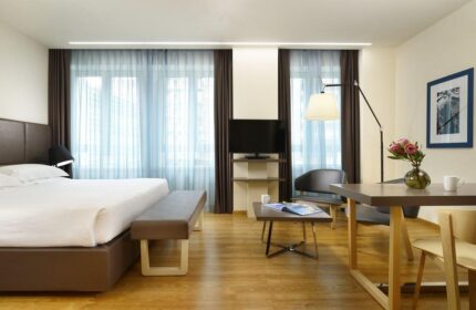 UNAHOTELS Century Milano gay-friendly hotel room. Modern design with bed, seating area, and desk. A comfortable stay for gay travelers in Milan.