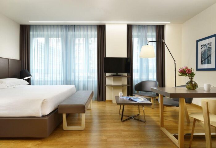 UNAHOTELS Century Milano gay-friendly hotel room. Modern design with bed, seating area, and desk. A comfortable stay for gay travelers in Milan.