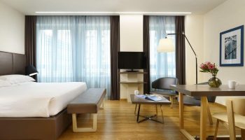UNAHOTELS Century Milano gay-friendly hotel room. Modern design with bed, seating area, and desk. A comfortable stay for gay travelers in Milan.