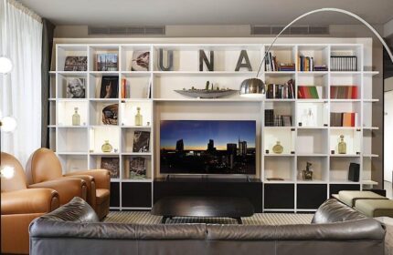 UNAHOTELS Century Milano gay-friendly hotel lounge area. Modern design, bookshelves, comfortable seating. Milan hotel for gay travelers.