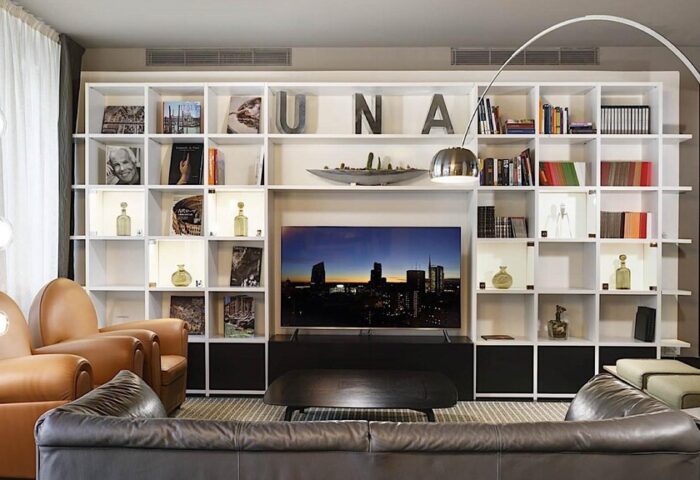 UNAHOTELS Century Milano gay-friendly hotel lounge area. Modern design, bookshelves, comfortable seating. Milan hotel for gay travelers.