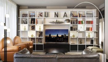 UNAHOTELS Century Milano gay-friendly hotel lounge area. Modern design, bookshelves, comfortable seating. Milan hotel for gay travelers.