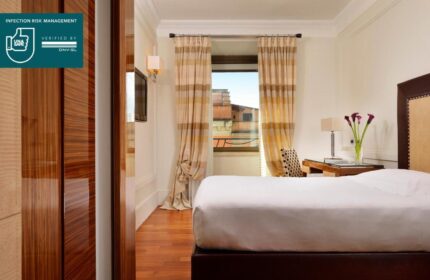 UNAHOTELS Decò Roma gay-friendly room. Pet-friendly hotel with a double bed, desk, and window with curtains. Infection risk management verified.