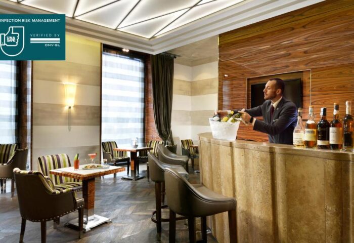 UNAHOTELS Decò Roma's gay-friendly bar. Bartender serves wine. Pet-friendly hotel with stylish decor, tables, and chairs. Ideal for gay travel.