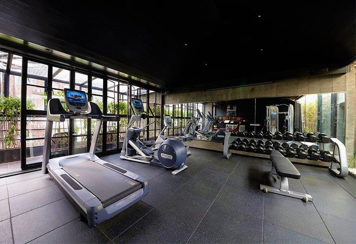 URBN Boutique Shanghai gay-friendly hotel gym. Treadmill, elliptical machines, weights, and mirrored wall in a modern fitness center.