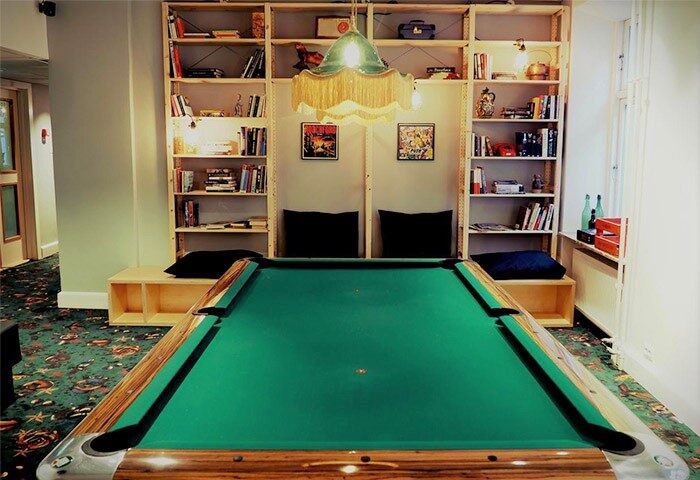 Urban House Copenhagen by MEININGER: A pool table, books, and a lamp create a cozy vibe at this gay-friendly hotel. Perfect for gay travelers.