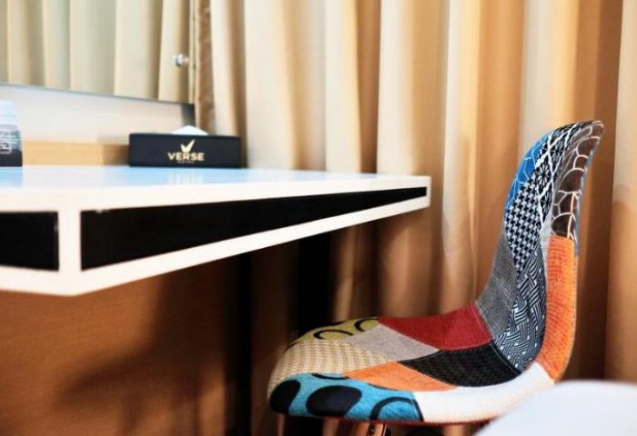 Verse Luxe Hotel Wahid Hasyim detail. Modern desk and colorful chair. Gay-friendly hotel room design. Interior of Jakarta hotel.