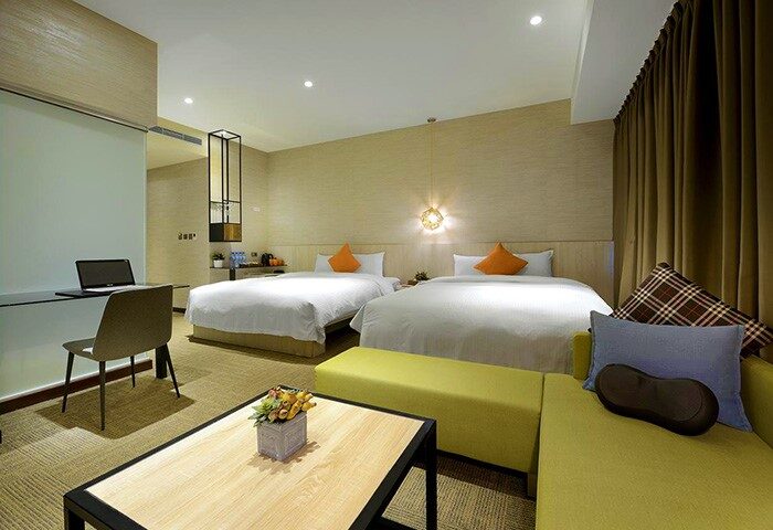Via Hotel Taipei Station room: Two beds, desk, & sofa. Gay-friendly hotel with modern decor. Ideal for gay travelers in Taipei.
