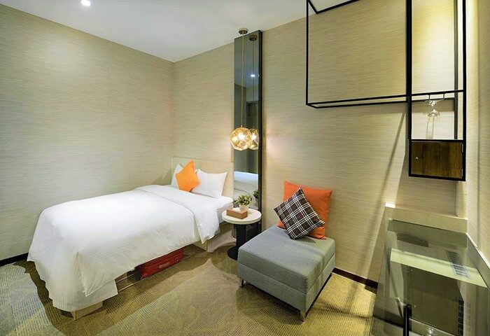 Via Hotel Taipei Station room. Gay-friendly hotel with single bed, ottoman, and modern decor. Taipei travel for gay men.