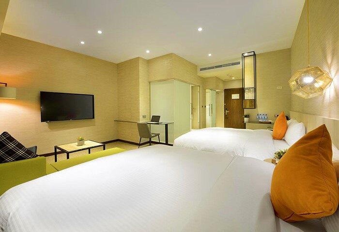 Via Hotel Taipei Station room. Gay-friendly hotel with two beds, TV, desk, and modern decor. Ideal for gay travelers in Taipei.