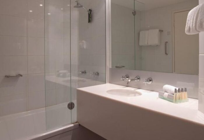 Vibe Hotel Sydney bathroom. Modern design, glass shower screen, white tiles, and sleek vanity. Gay-friendly hotel for discerning travelers.