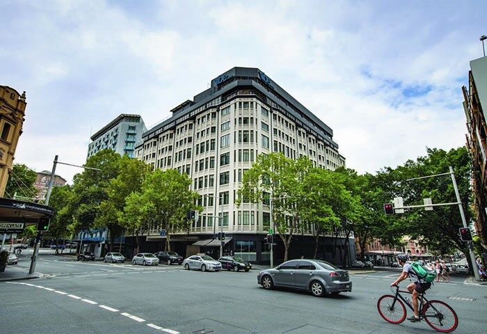Vibe Hotel Sydney exterior view. Gay-friendly hotel with modern architecture. Cityscape, street view, and urban setting. Great for gay travelers.