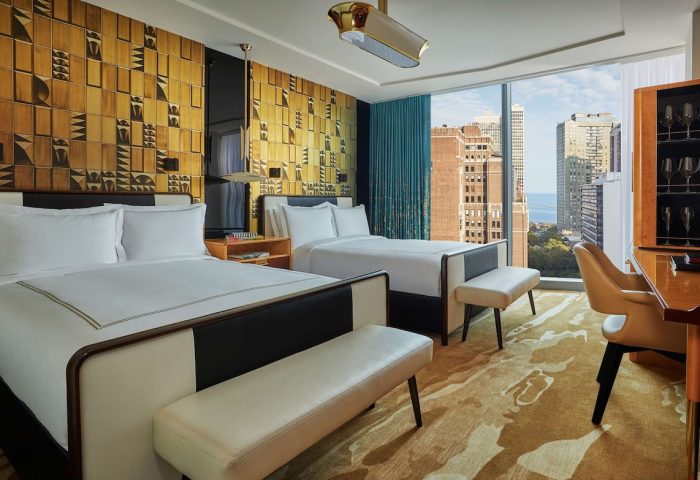 Viceroy Chicago hotel room with two beds, city view, desk, and stylish decor. Gay-friendly travel lodging in Chicago. Interior design details.