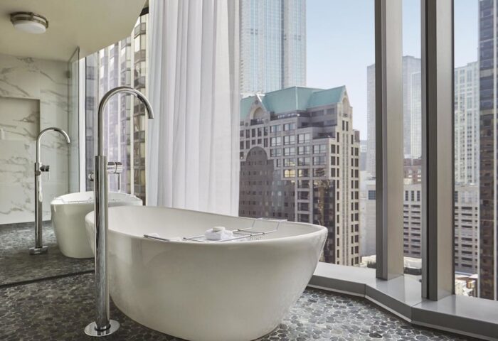 Viceroy Chicago gay-friendly hotel bathroom with soaking tub. City views from window. Upscale travel for gay men in Chicago.