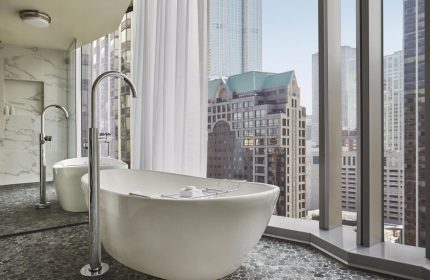 Viceroy Chicago gay-friendly hotel bathroom with soaking tub. City views from window. Upscale travel for gay men in Chicago.
