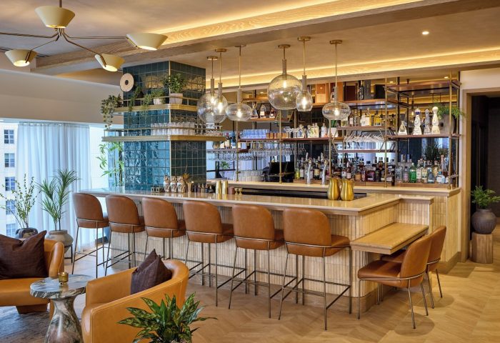 Viceroy Chicago gay-friendly hotel bar area. Leather bar stools, liquor shelf, and globe lighting. Upscale travel for gay men.