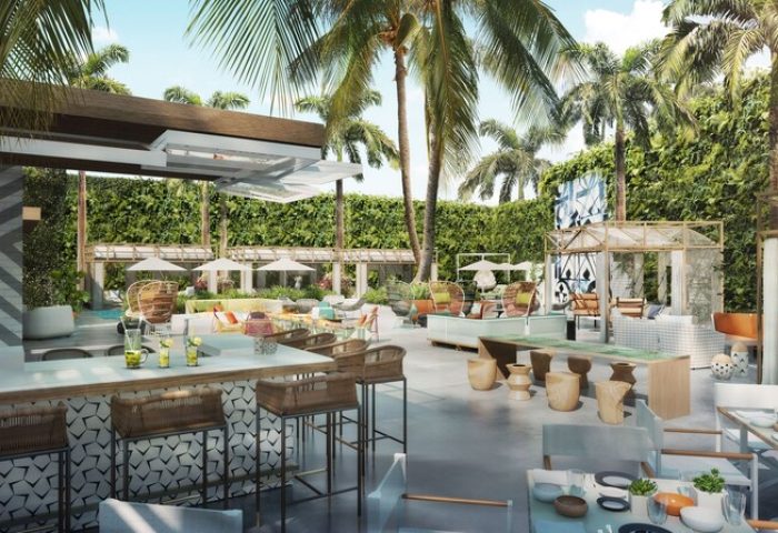 Viceroy Santa Monica gay-friendly hotel patio. Outdoor bar, tables, seating, and palm trees. A luxury travel destination for gay men.