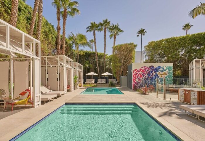Viceroy Santa Monica gay-friendly hotel pools. Cabanas, lounge chairs, palm trees, and colorful geometric mural. Ideal for gay travel.