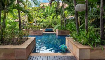 Victoria Angkor Resort & Spa pool. Lush tropical garden setting. Gay-friendly hotel. Swimming pool with blue tile and a beach ball.