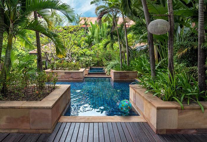 Victoria Angkor Resort & Spa pool. Lush tropical garden setting. Gay-friendly hotel. Swimming pool with blue tile and a beach ball.