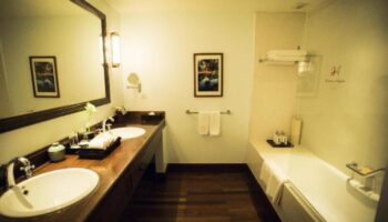 Bathroom at gay-friendly Victoria Angkor Resort & Spa. Double sink, wood floors, bathtub. Luxury hotel for gay men in Siem Reap, Cambodia.