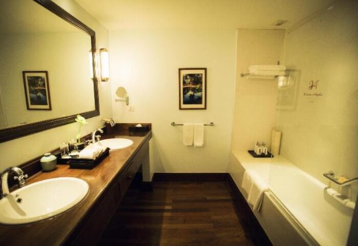 Bathroom at gay-friendly Victoria Angkor Resort & Spa. Double sink, wood floors, bathtub. Luxury hotel for gay men in Siem Reap, Cambodia.