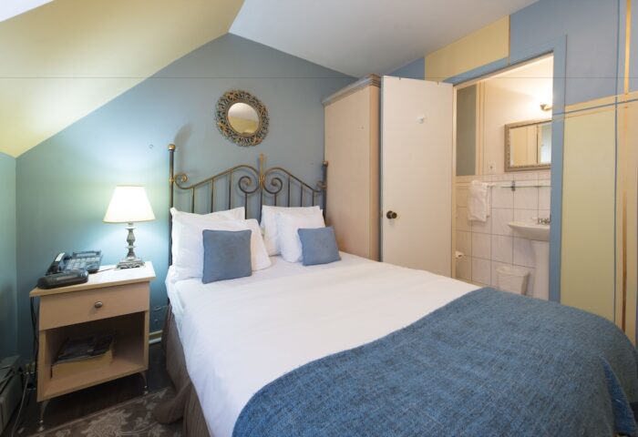 Victoria's Mansion Guest House room. Gay-friendly hotel bedroom with bed, nightstand, and bathroom. Travel advice for gay men.
