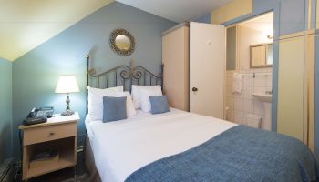 Victoria's Mansion Guest House room. Gay-friendly hotel bedroom with bed, nightstand, and bathroom. Travel advice for gay men.