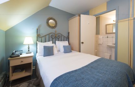 Victoria's Mansion Guest House room. Gay-friendly hotel bedroom with bed, nightstand, and bathroom. Travel advice for gay men.