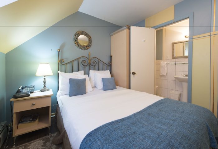 Victoria's Mansion Guest House room. Gay-friendly hotel bedroom with bed, nightstand, and bathroom. Travel advice for gay men.