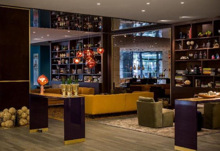 Vienna House Andel's Berlin lobby area. Gay-friendly hotel with pet-friendly options. Modern design, colorful furniture, and stylish lighting.