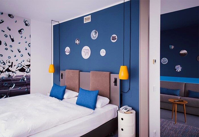 Vienna House Easy Berlin hotel room. Modern design, blue walls, and unique decor. A gay-friendly accommodation choice in Berlin.