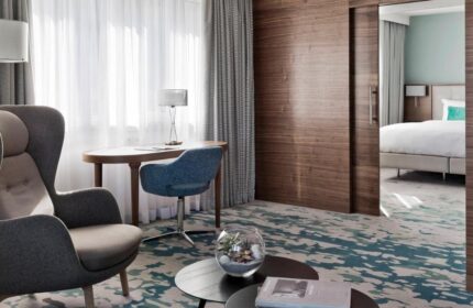 Vienna Marriott Hotel's gay-friendly room. Features a chair, desk, and bedroom view. Ideal for gay men travel.