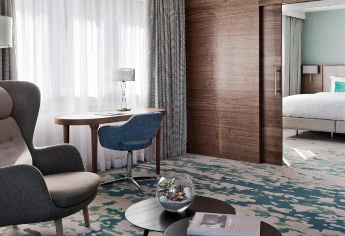 Vienna Marriott Hotel's gay-friendly room. Features a chair, desk, and bedroom view. Ideal for gay men travel.