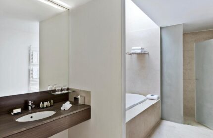 Vienna Marriott Hotel bathroom. Gay-friendly hotel with modern design, featuring a sink, mirror, bathtub, and shower. Great for gay travel.